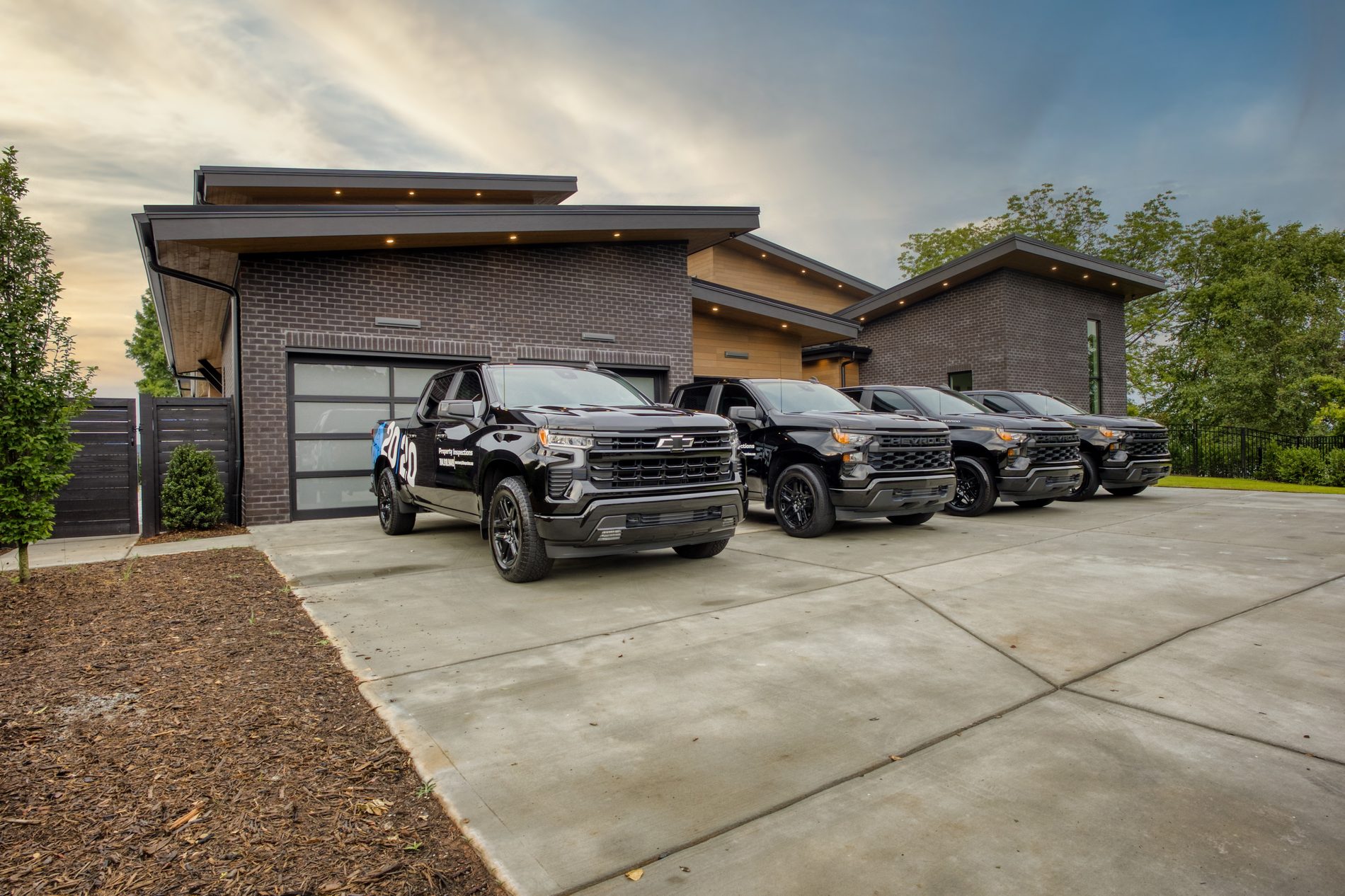 20/20 Property Inspections fleet of blacked-out trucks at dusk